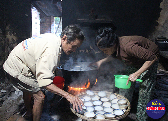 Vợ chồng chú Sự đang lấy bánh ra từ lò. Ảnh: L.T